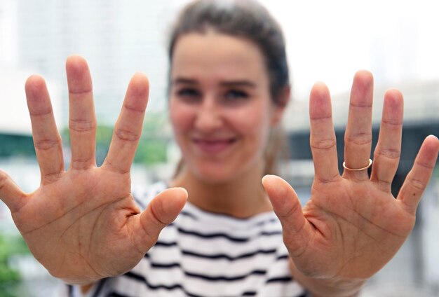 Foto ritratto di una donna che fa un segno di arresto in città