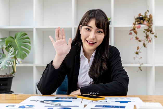 カメラの前で話しているジェスチャーをしている女性の肖像画、人とビデオ通話をしているように両手を上げている美しいビジネスウーマン。ビデオ会議のビジュアルコンセプト。