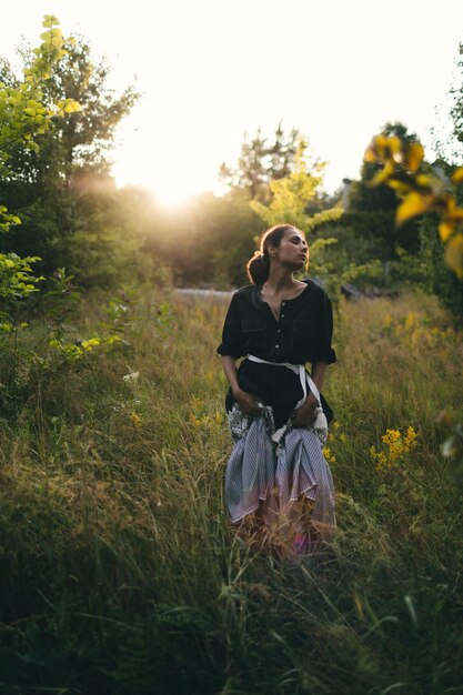 Portrait of woman in golden sunset light in outdoor meadow Springtime and summer lifestyle Wellbeing and zen like meditation activity in outdoor Loving life