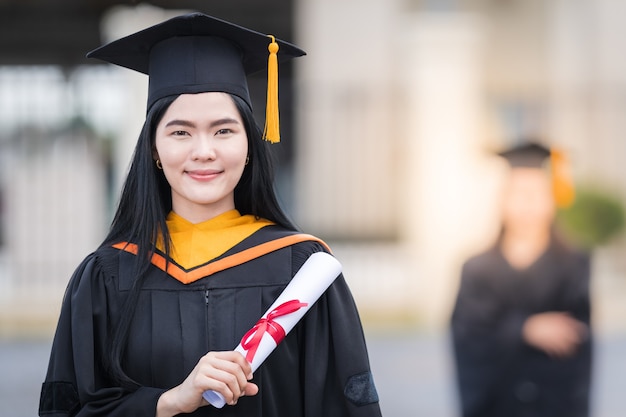 Ritratto di una donna laureata in possesso di un certificato di laurea alla cerimonia di laurea