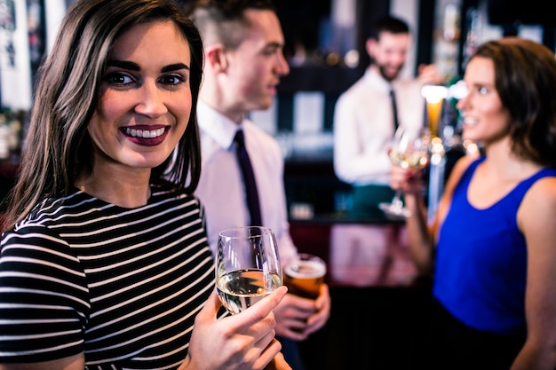 Portrait of woman having a drink with friends in a bar