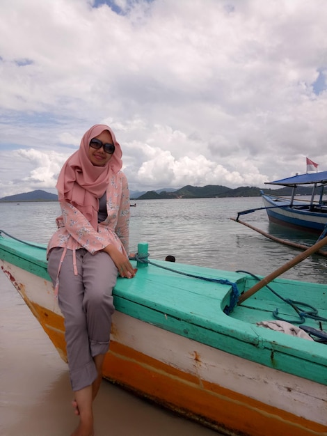 Portrait of woman in hijab sitting on boat moored at beach