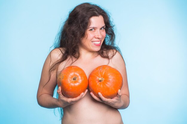 Portrait of woman holding apple against blue background