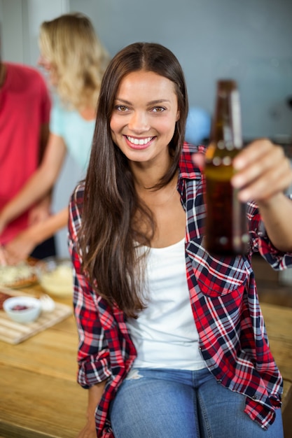 自宅でビール瓶を保持している女性の肖像画