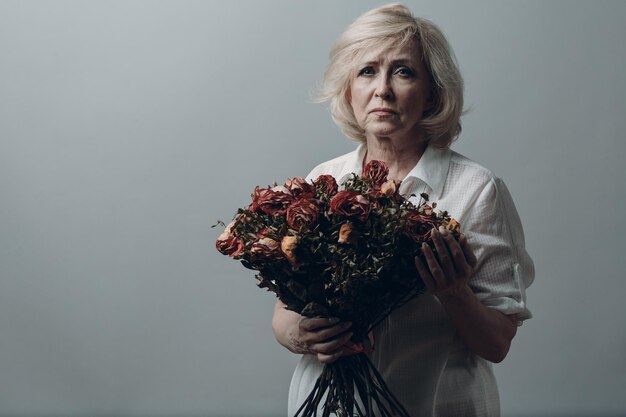 Photo portrait of woman holding bouquet against white background