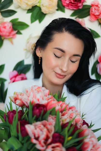 Portrait of woman holding bouquet of pink flowers photo