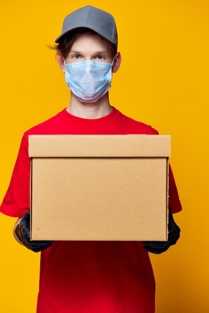 Portrait of woman holding box against yellow background