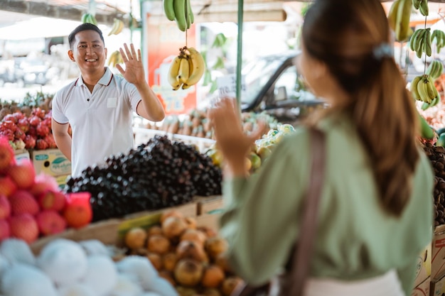 Foto ritratto di una donna con dei frutti al mercato