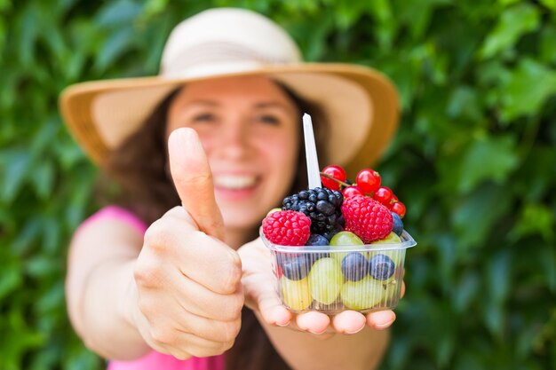 Foto ritratto di una donna con dei frutti in mano