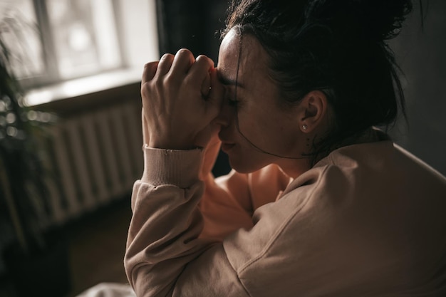 Foto ritratto di una donna che tiene le mani sul letto a casa