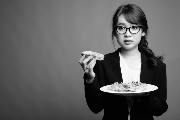 Foto ritratto di una donna con un gelato sullo sfondo grigio