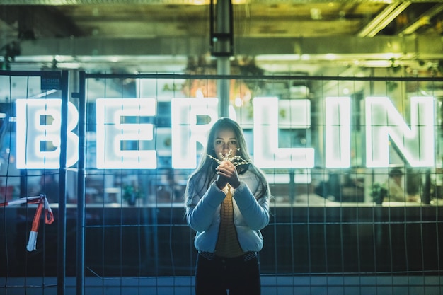 Photo portrait of woman holding illuminated string light at night