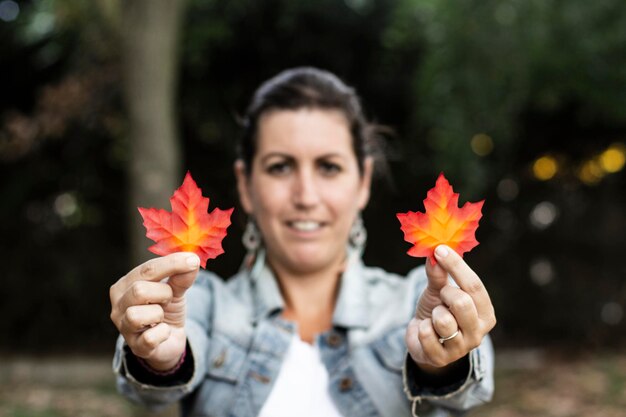 Foto ritratto di una donna che tiene le foglie durante l'autunno