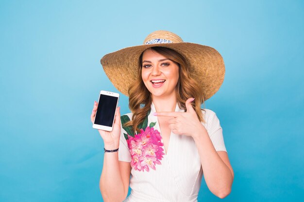 Portrait of woman holding mobile phone against blue background
