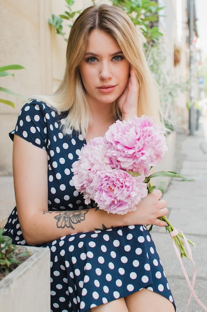 Portrait of a woman holding peonies