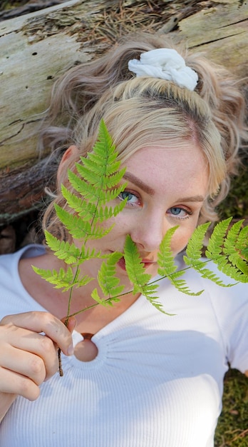 Foto ritratto di una donna che tiene una pianta