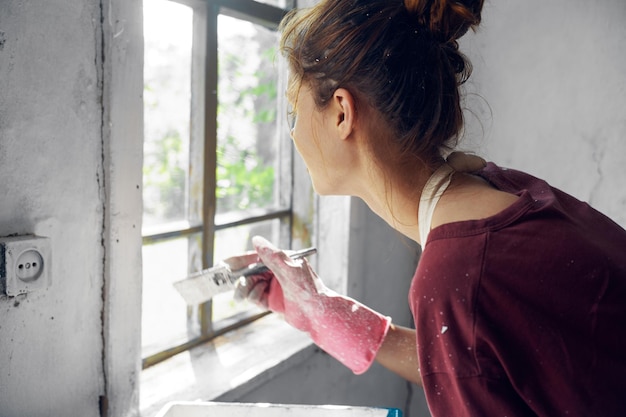 Foto ritratto di una donna che tiene il rosso mentre è in piedi vicino alla finestra a casa