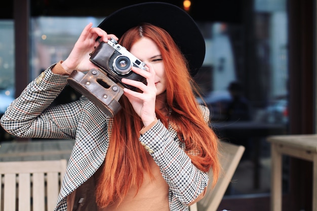 Photo portrait of a woman holding a retro camera