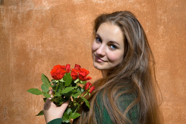 Foto ritratto di una donna che tiene un bouquet di rose.