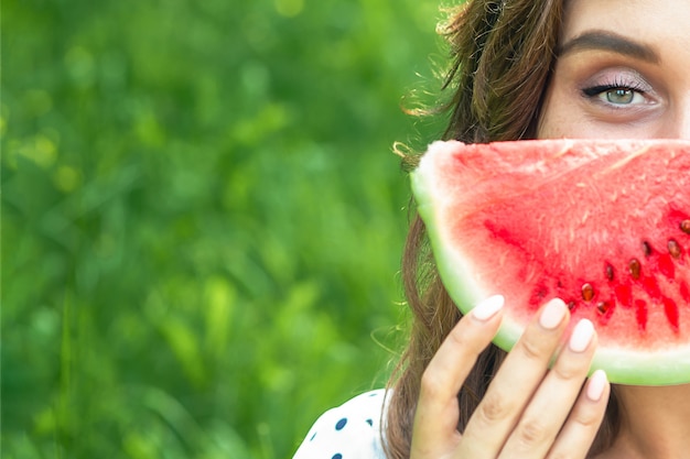 Photo portrait of woman holding slice of watermelon.