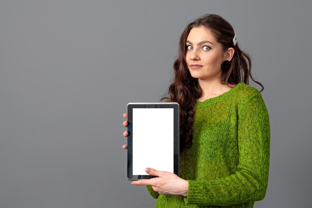 Photo portrait of woman holding smart phone while standing against gray background