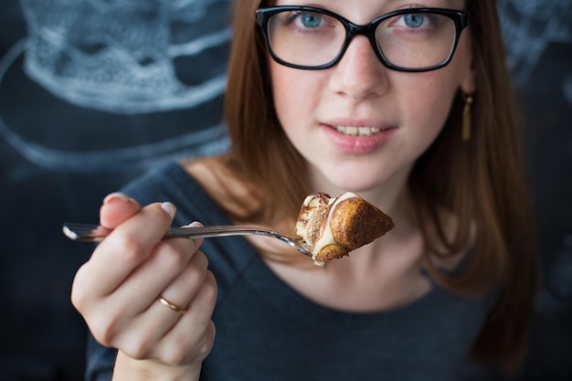 カフェで甘い食べ物を握っている女性の肖像画