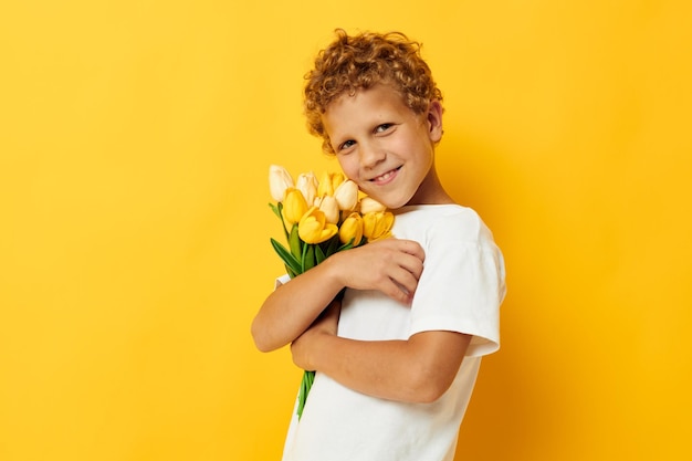 Photo portrait of woman holding yellow flowers against orange background