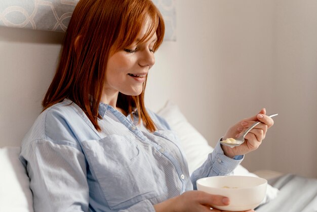 Foto donna del ritratto a mangiare a casa