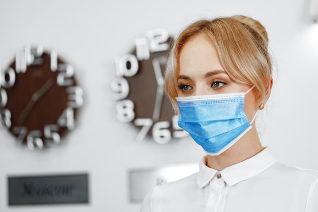 Portrait of woman hotel receptionist wearing medical mask