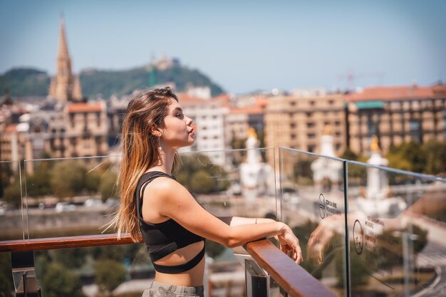 Портрет женщины на террасе отеля, смотрящей на город сверху