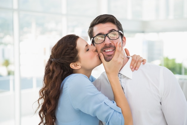 Portrait of a woman kissing her colleague 