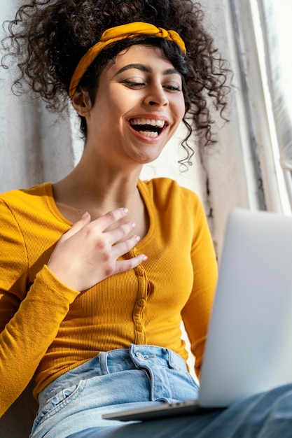 Photo portrait of woman laughing while using laptop
