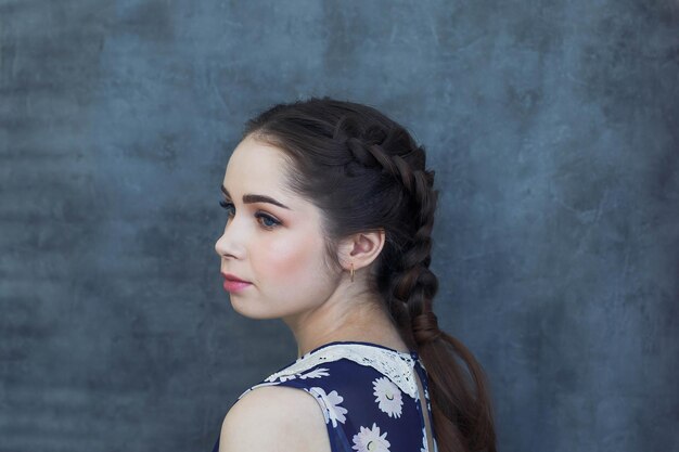 Portrait of woman looking away against wall