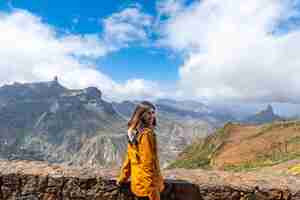 Photo portrait of a woman looking at roque nublo from a viewpoint on the mountain gran canaria spain