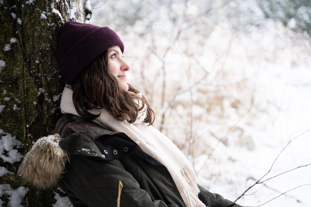 Portrait of woman looking at tree during winter