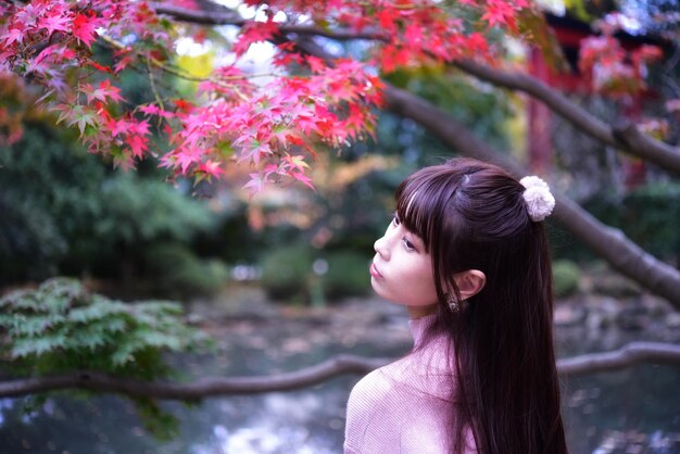 Foto ritratto di una donna che guarda un albero