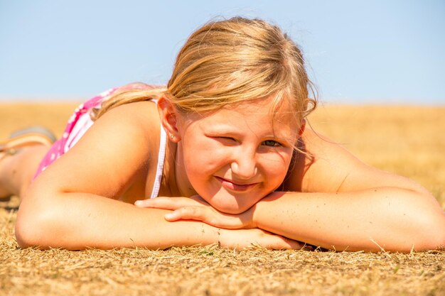 Portrait of woman lying down on sand at beach against sky