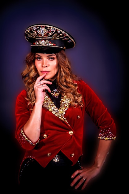 Portrait woman magician illusionist circus in theatrical clothes deep thinking at black background Female actress in stage costume and stylish hat thoughtful