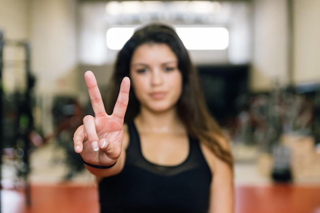 Portrait of a woman making a peace sign