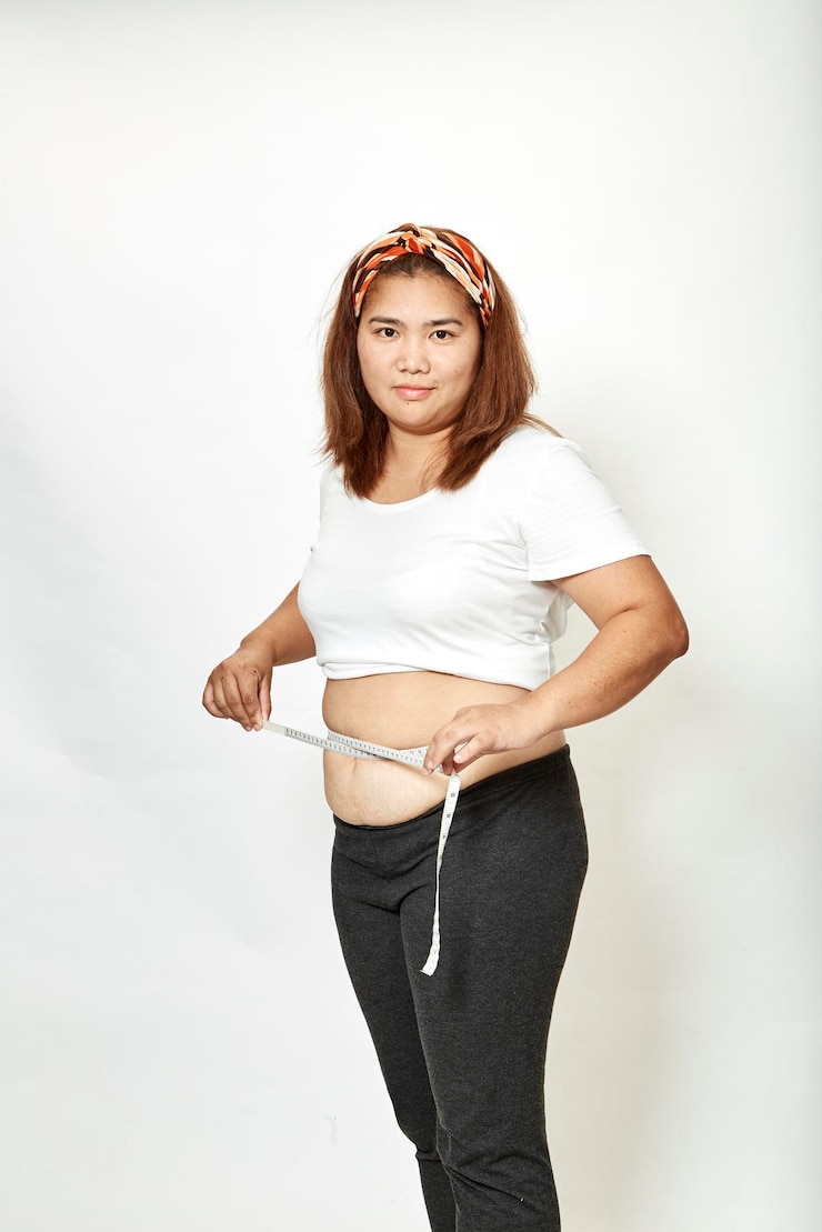 Photo 白い背景で腹部を測定している女性の肖像画
