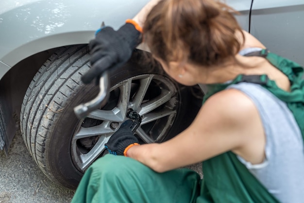 道路側の壊れた車の近くの女性整備士の肖像画