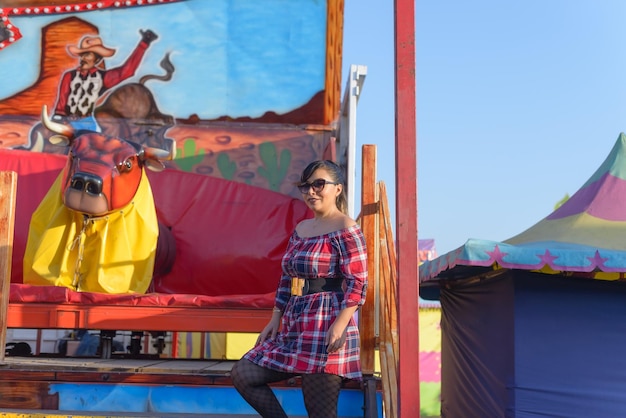 Portrait of a woman next to a mechanical bull at a fair in Mexico