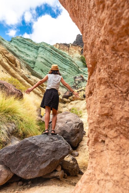 Portrait of a woman at the natural monument at the Azulejos de Veneguera or Rainbow Rocks in Mogan Gran Canaria