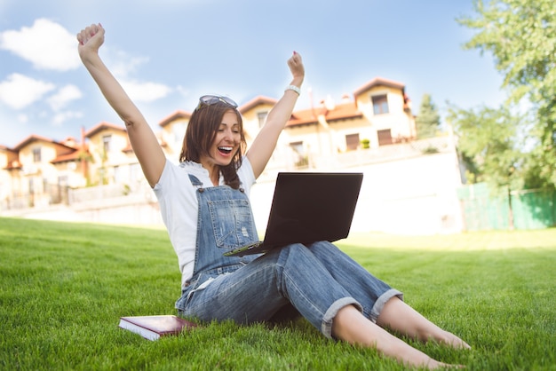 Portrait woman in park with laptop