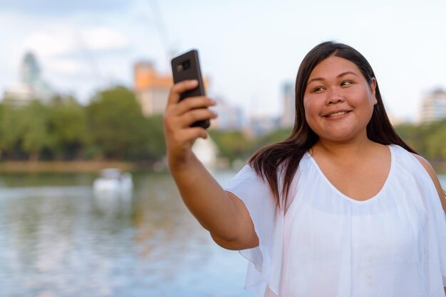 Photo portrait of woman photographing with mobile phone