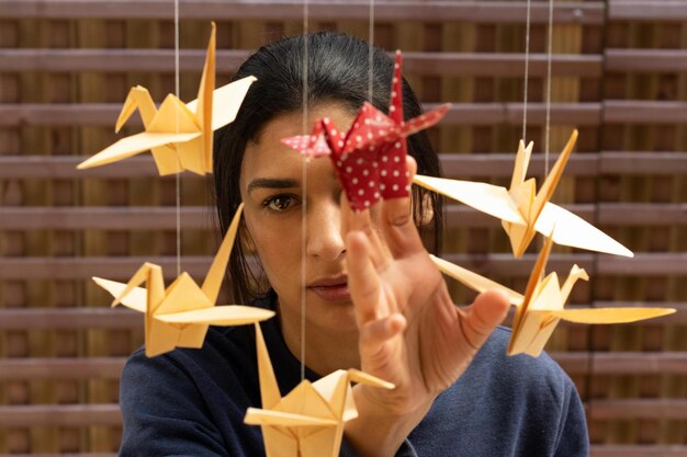 Foto ritratto di una donna che gioca con la decorazione dell'origami