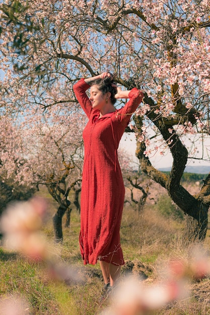 Портрет женщины, позирующей с миндальным деревом и весенней атмосферой