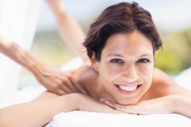 Portrait of woman receiving a back massage from masseur in a spa