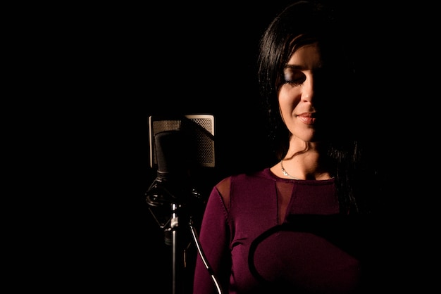 Portrait of woman recording a song in a professional studio