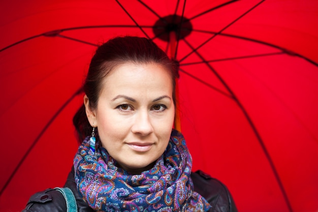 Portrait of a woman under red umbrella